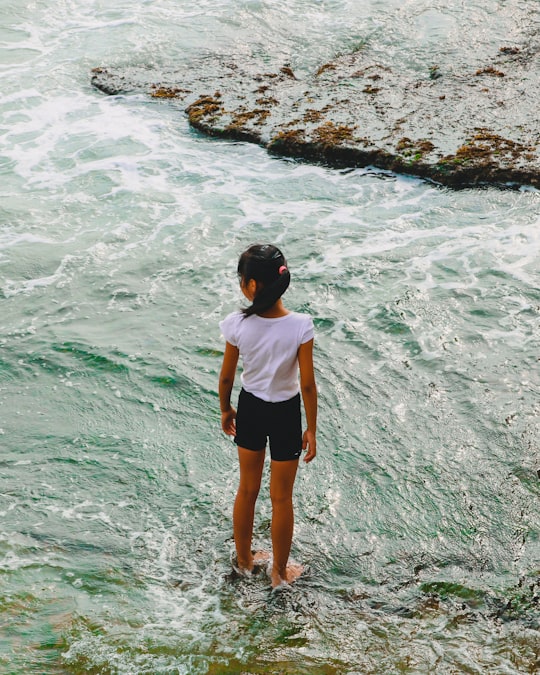 girl standing on the rock and body of water in Colombo Sri Lanka