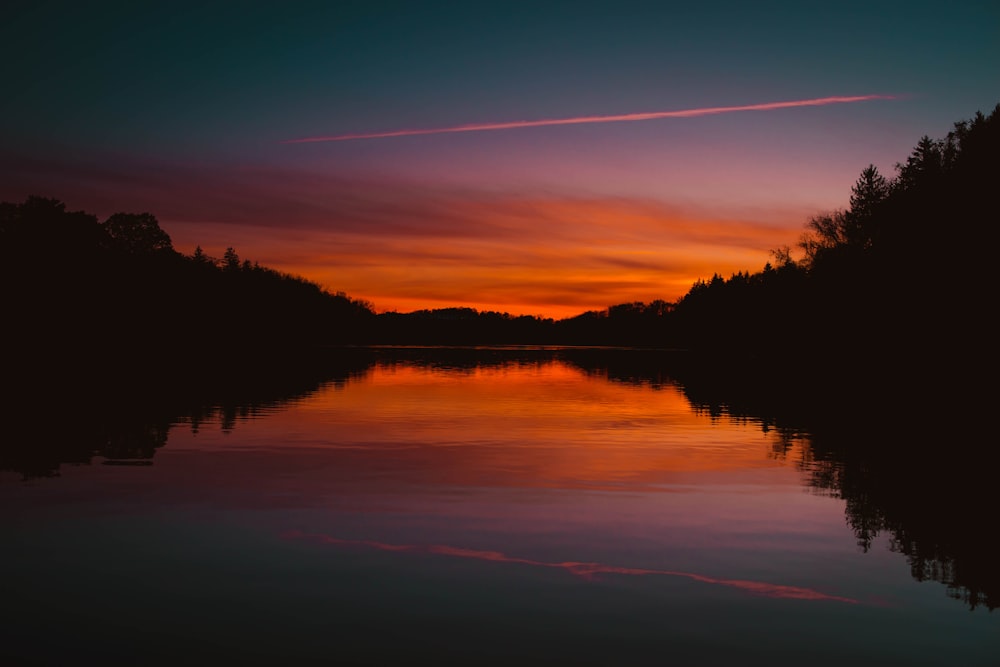 red sky reflecting body of water