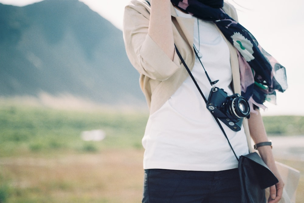 person carrying a black DSLR camera