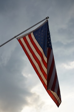 Stars and stripes flag waving gently over a children's playground.