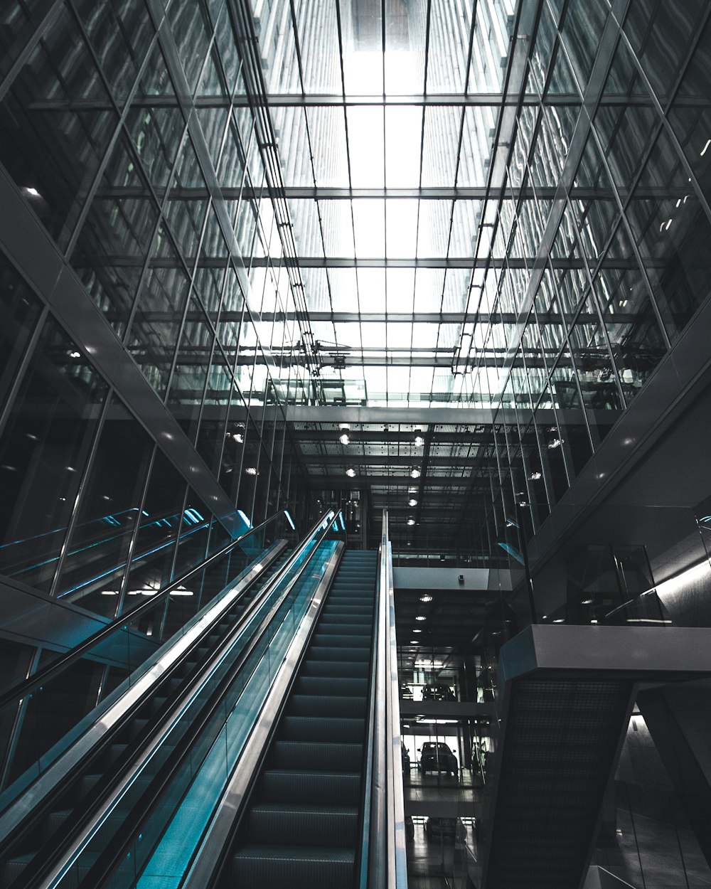 black escalator inside glass building