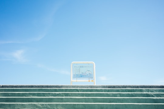 white metal framed board on stairway under blue sky in Nago Japan