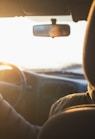 man driving car during golden hour