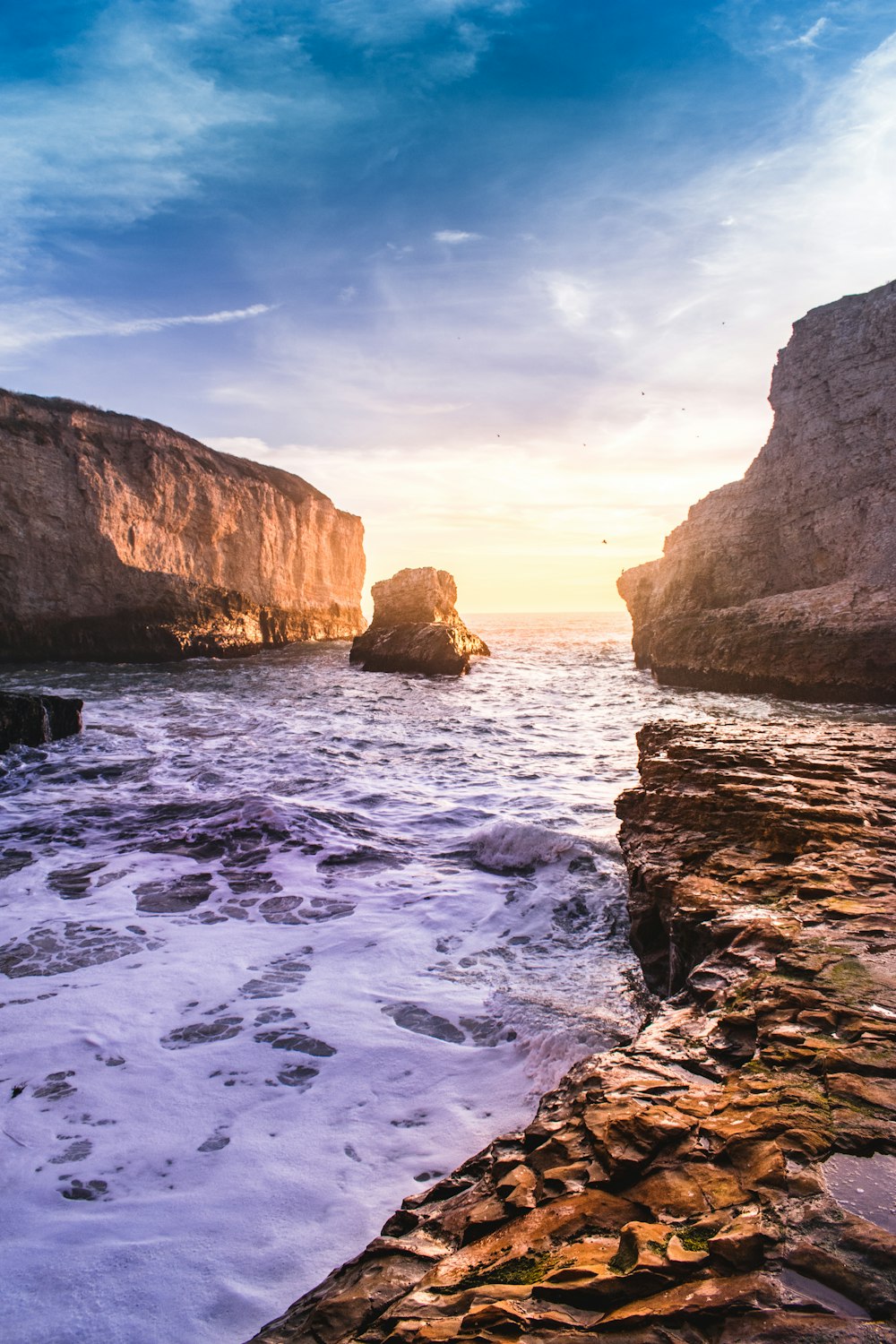 a rocky beach with waves crashing against the rocks