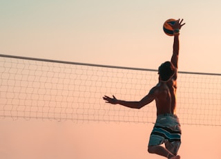 man playing beach volleyball during daytime