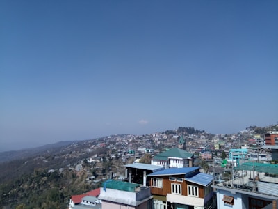 A panoramic view of Shimla town with colorful houses nestled on the hillside.