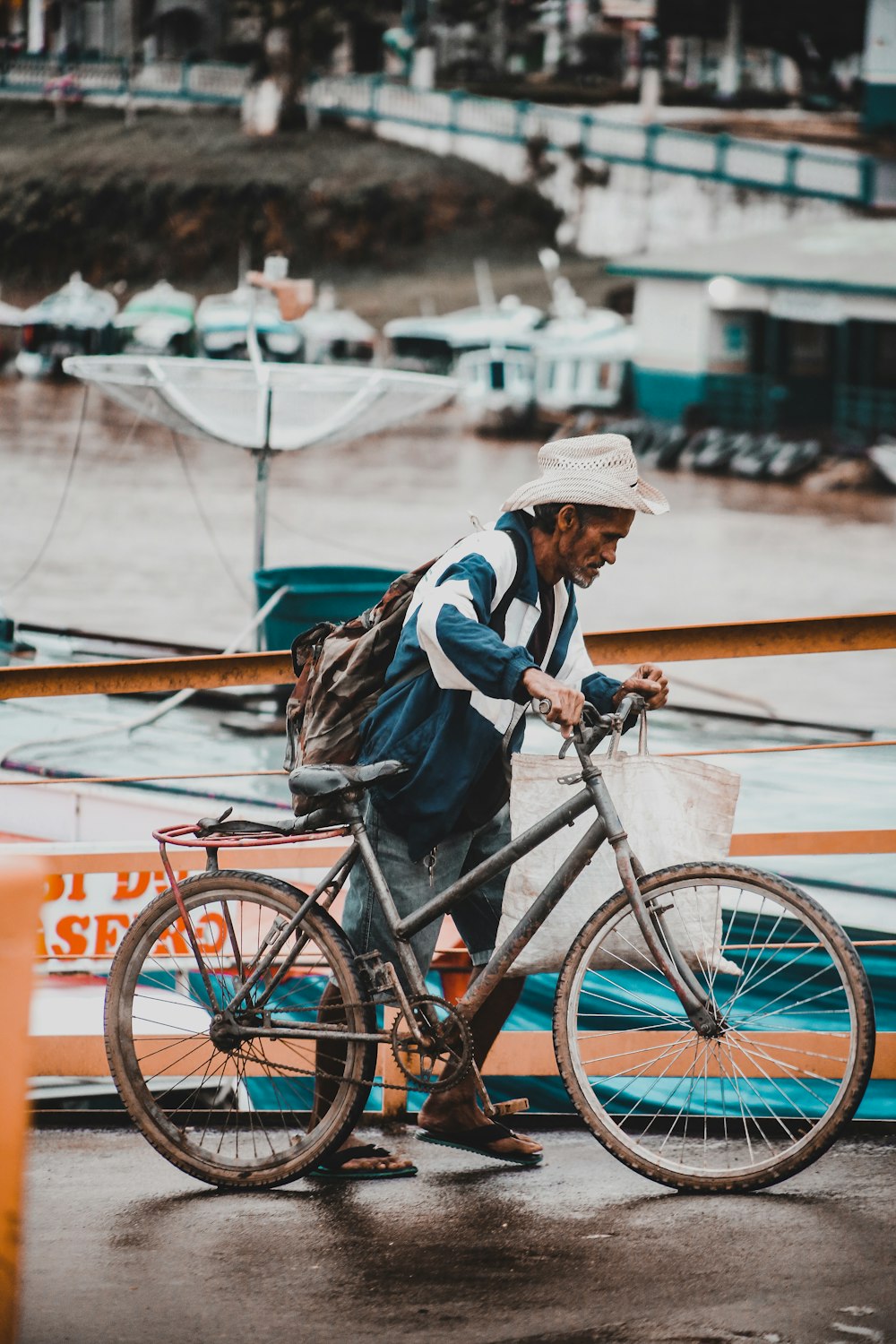 hombre sosteniendo una bicicleta cerca del mar
