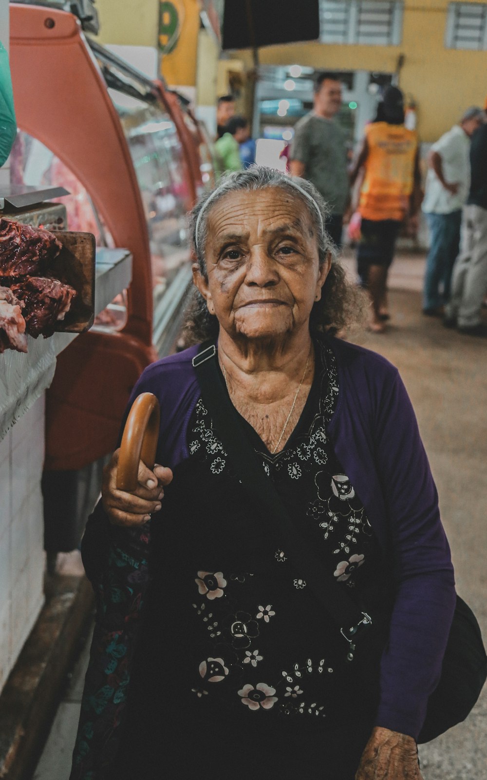 mulher em pé perto do vidro enquanto olha a câmera