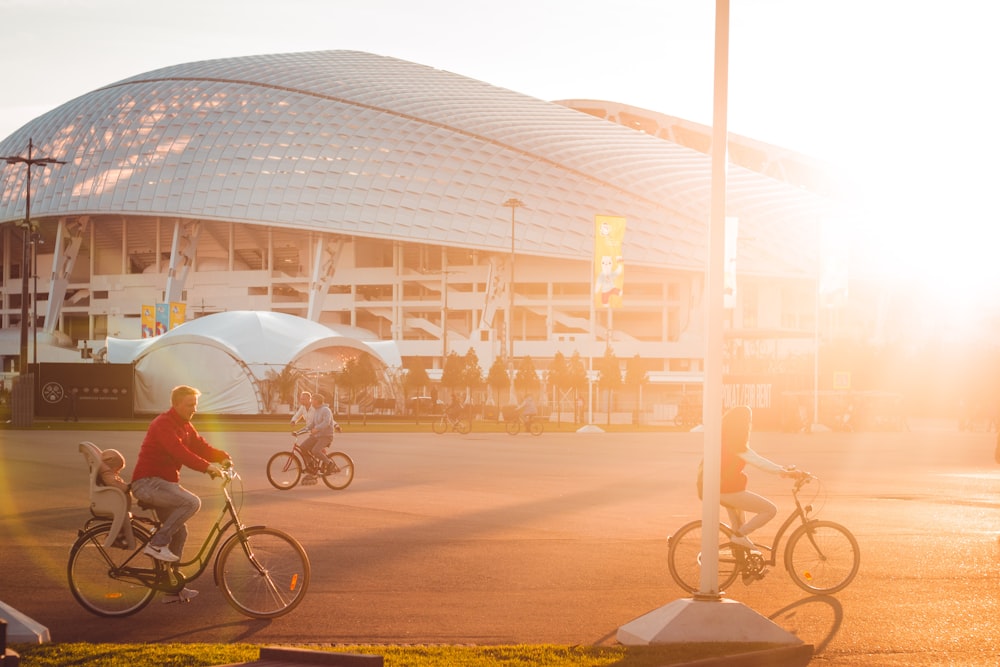 three people riding bicycles on park