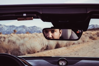person staring at rear view mirror