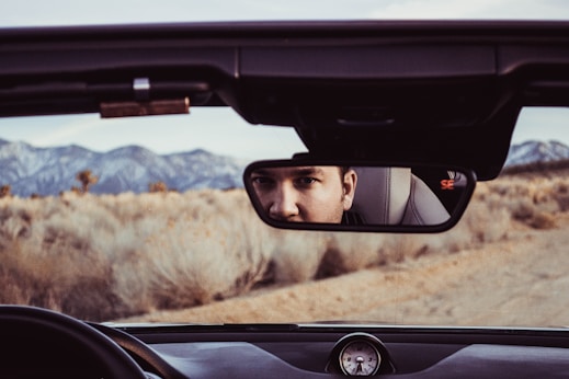 person staring at rear view mirror
