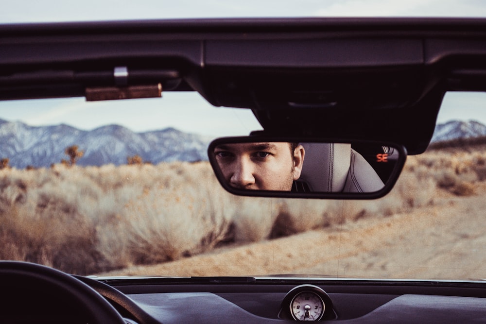 person staring at rear view mirror