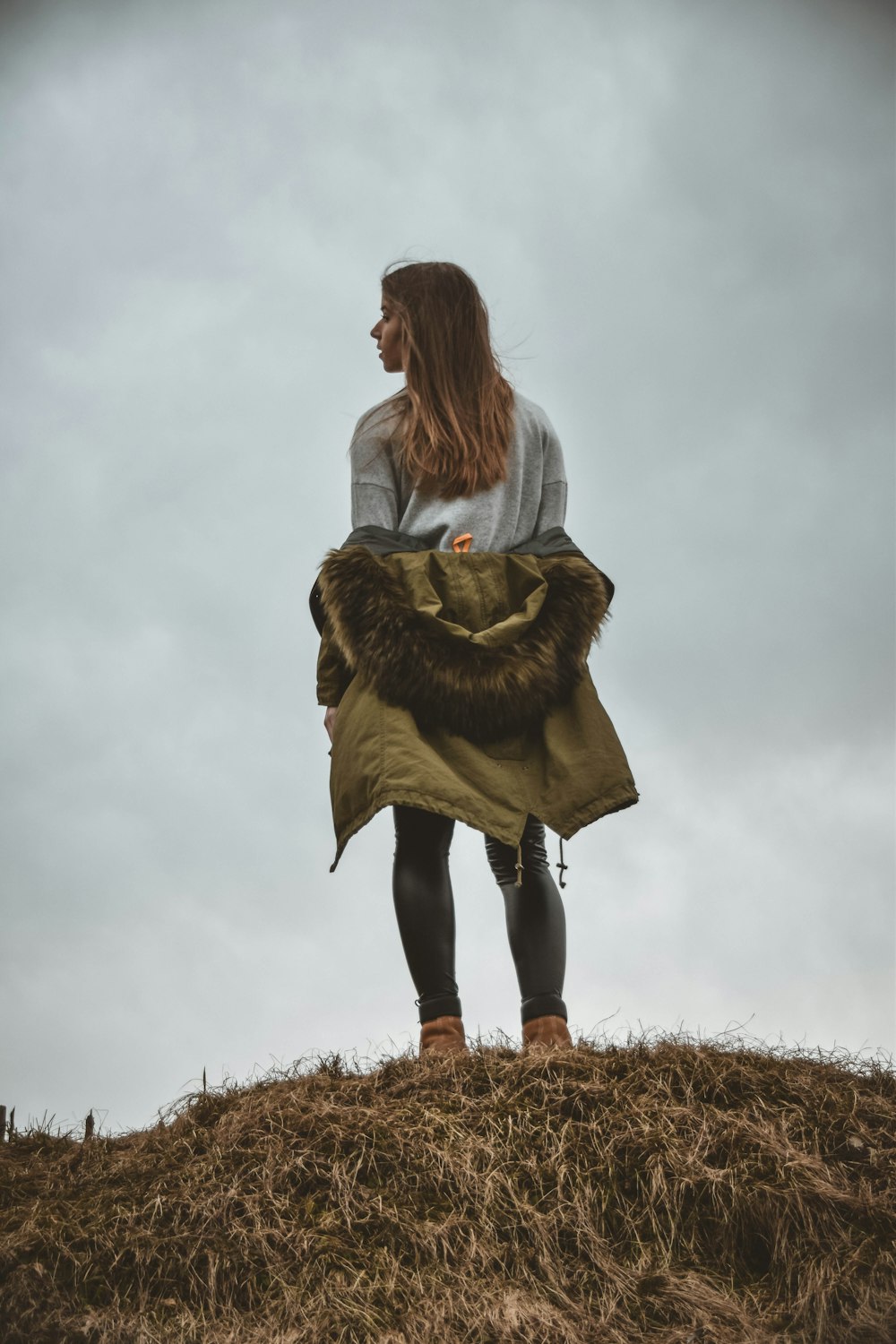 mujer de pie en el borde de la montaña