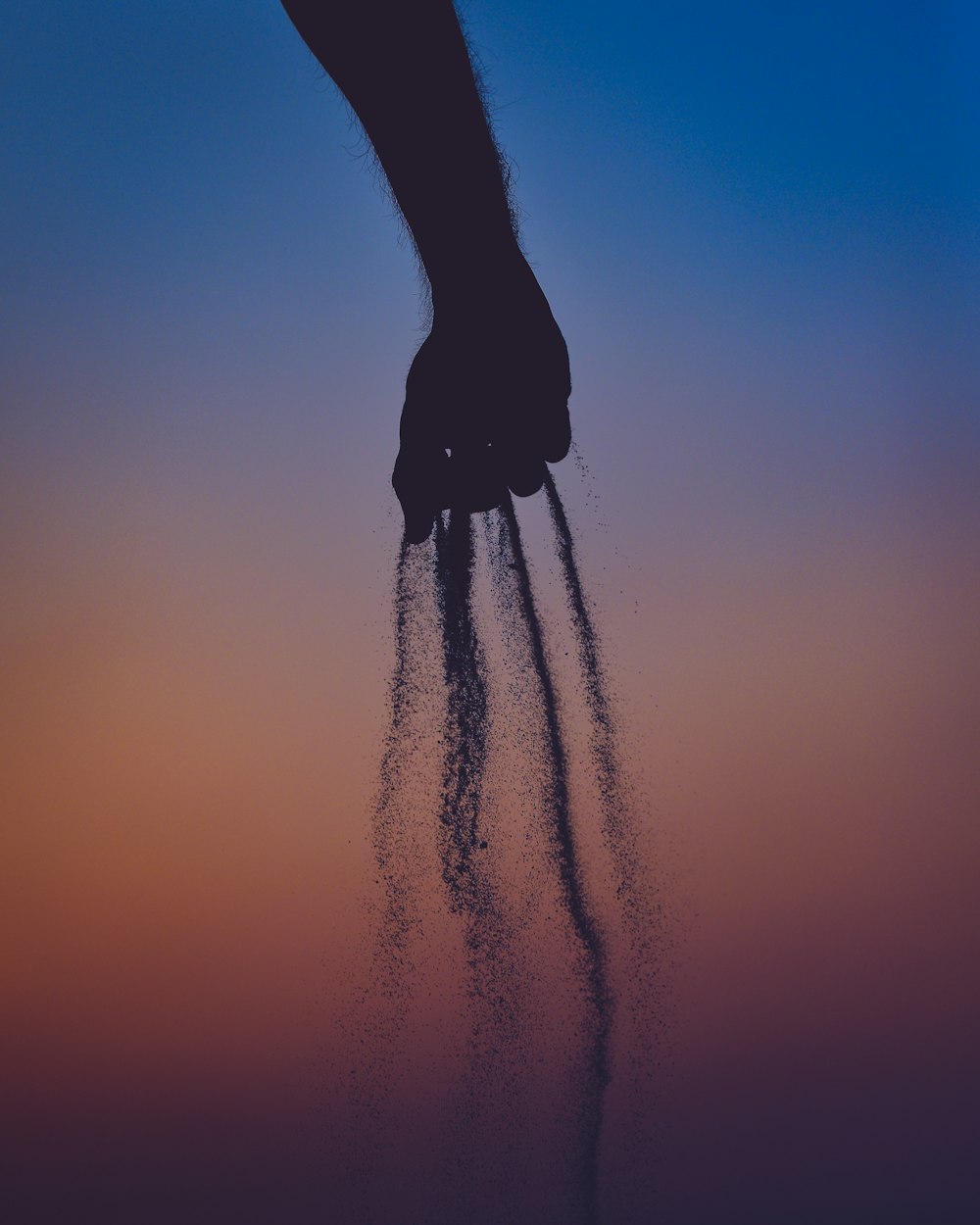 person dropping sand from his hands