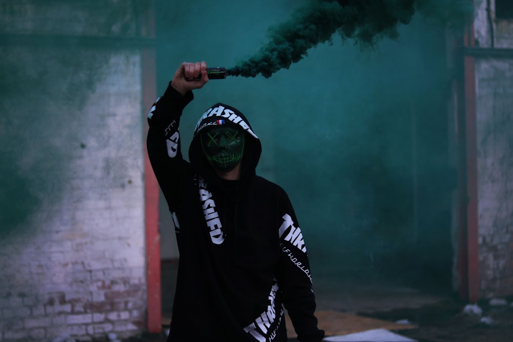 man holding a black signalling smoke