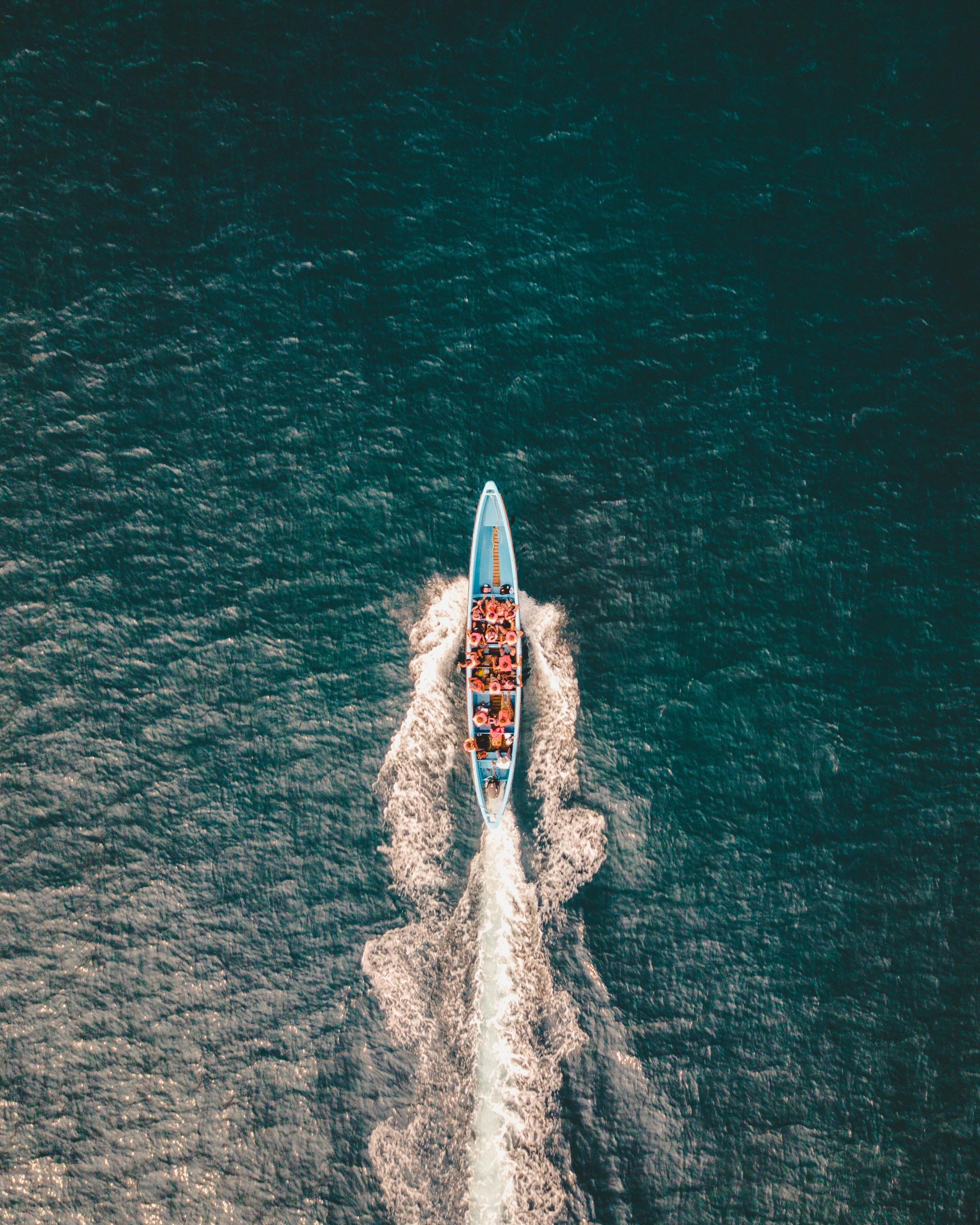 bird's eye view of blue boat on body of water