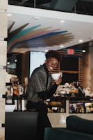 A smiling customer holding a cup of Cristine coffee, surrounded by calming coffee brown and soft green tones.