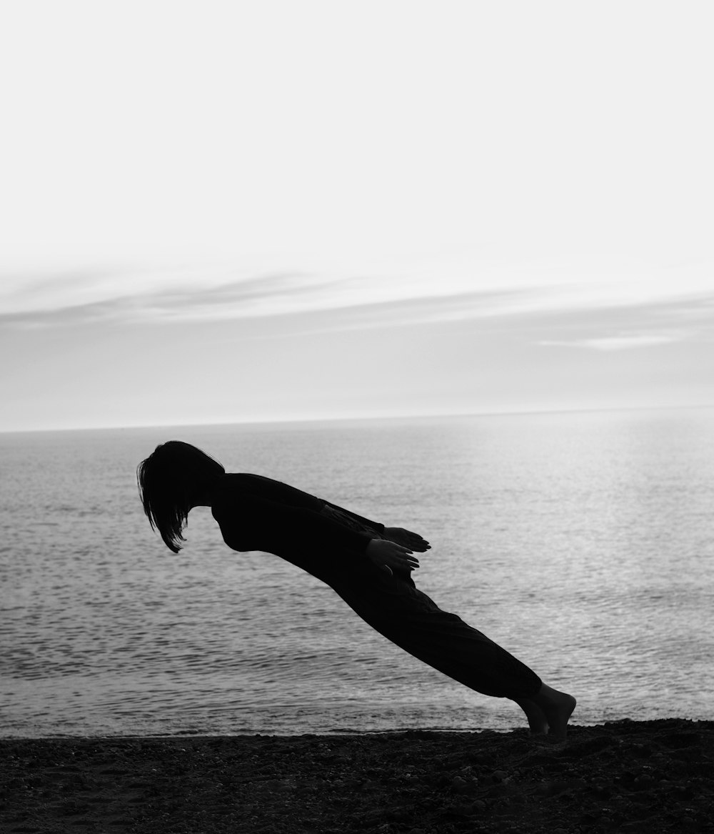 person doing gravity lean on the shore