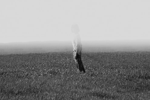 grayscale photo of person standing on field
