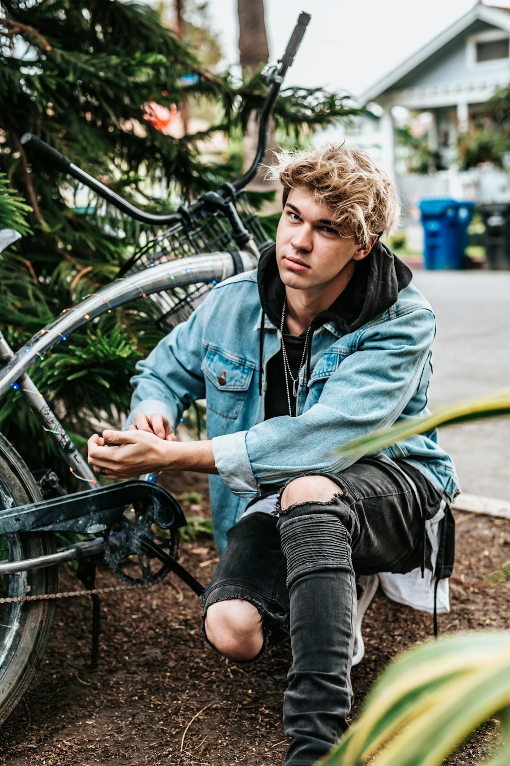 man laying his knees on ground beside cruiser bicycle