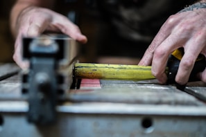 person holding yellow steel measuring tape in closeup photo