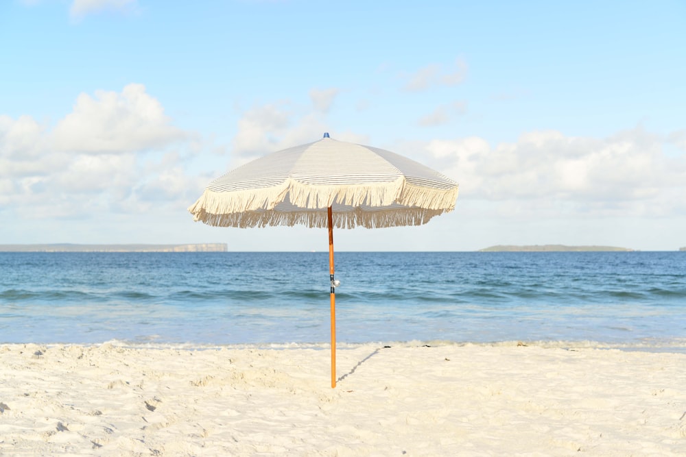 white umbrella on seashore