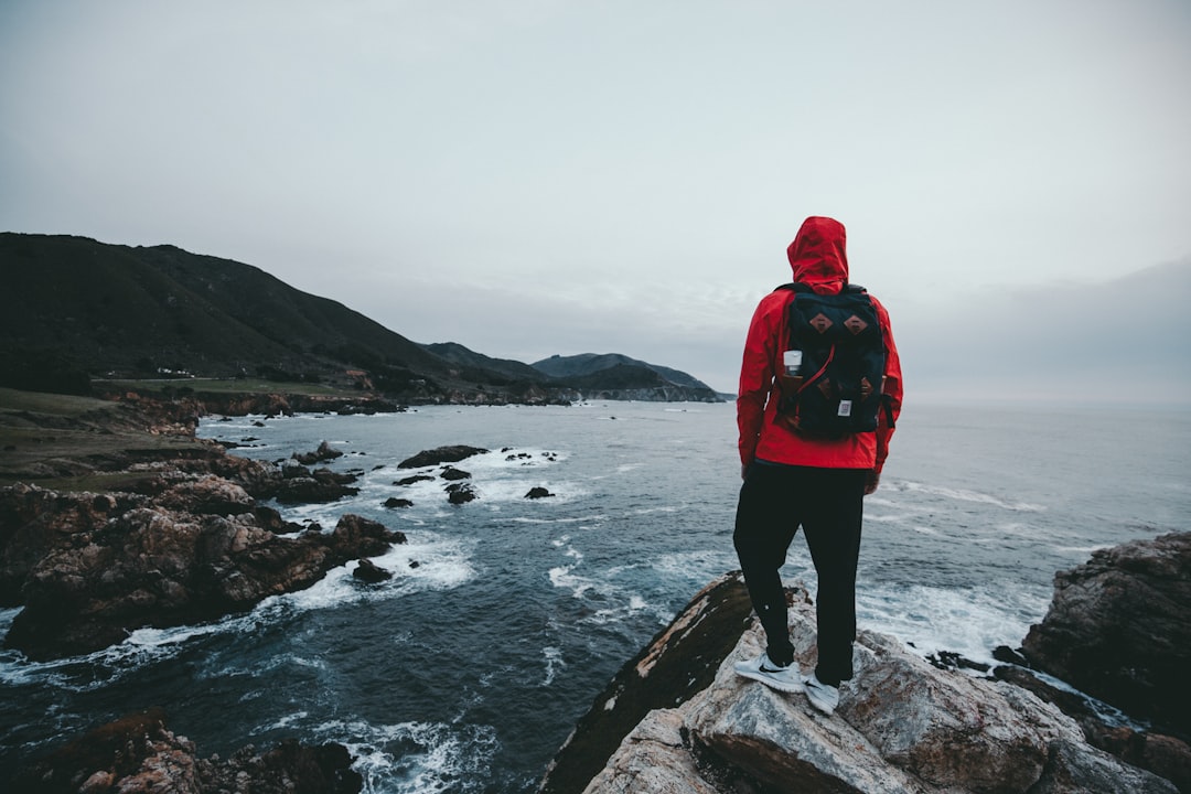 man standing on gray and black rock formation, Out on the distance