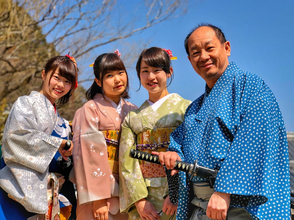 刀を持った男の横に着物を着た3人の女性