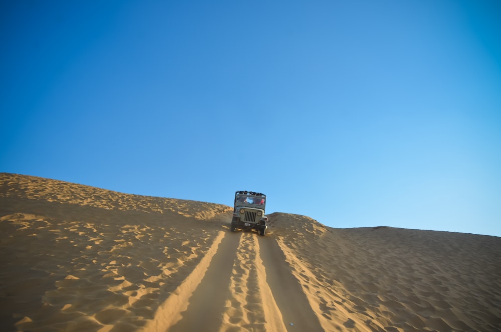 white car travelling on desert