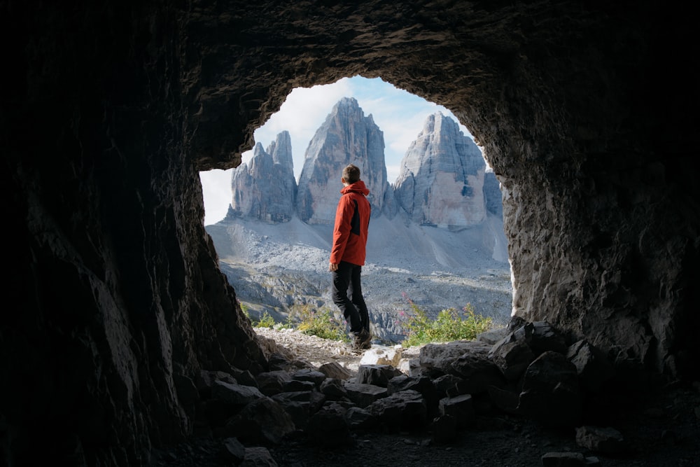 man standing in front of cave
