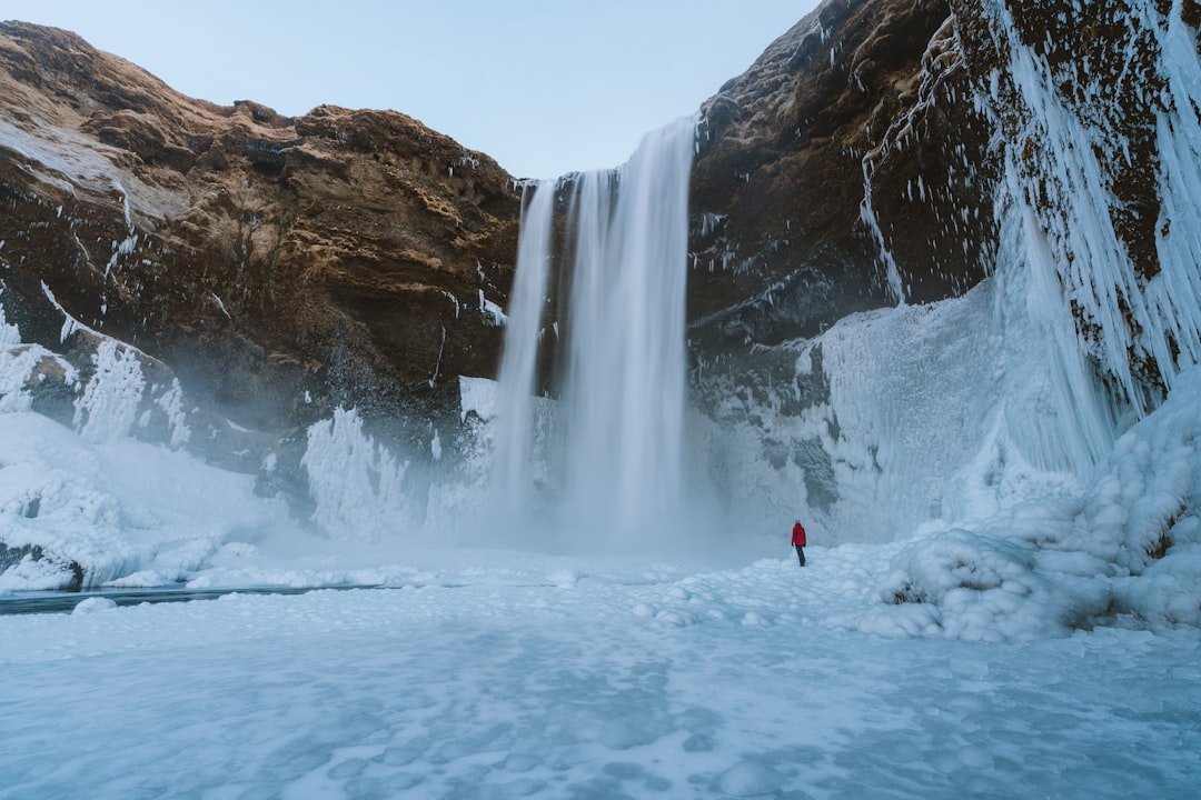 person standing near waterfalls