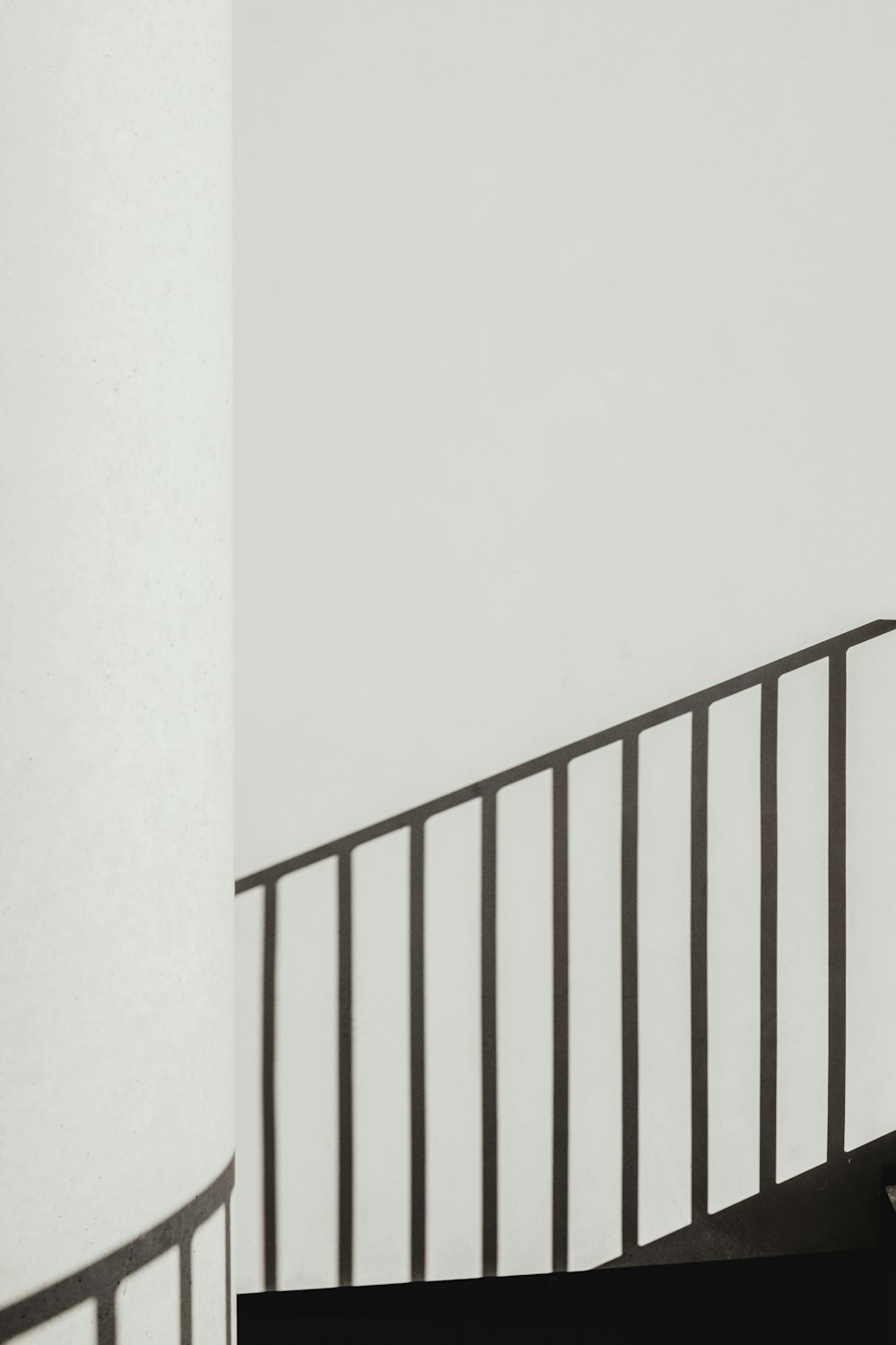 shadow of stair rails on white painted wall