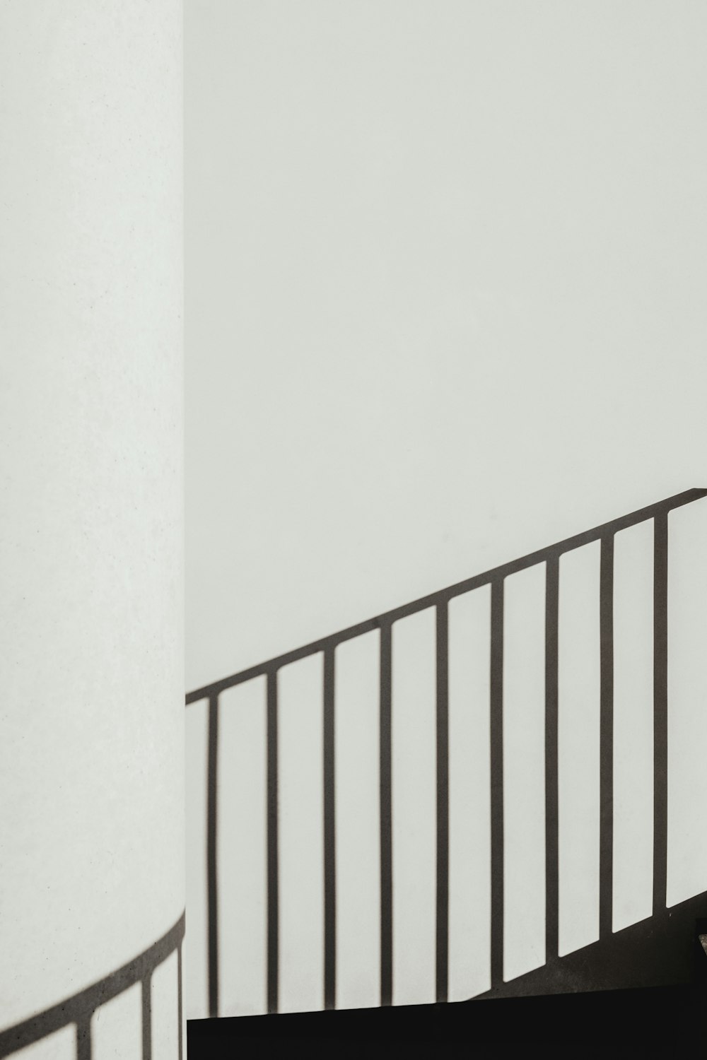 Sombra de barandillas de escalera en pared pintada de blanco