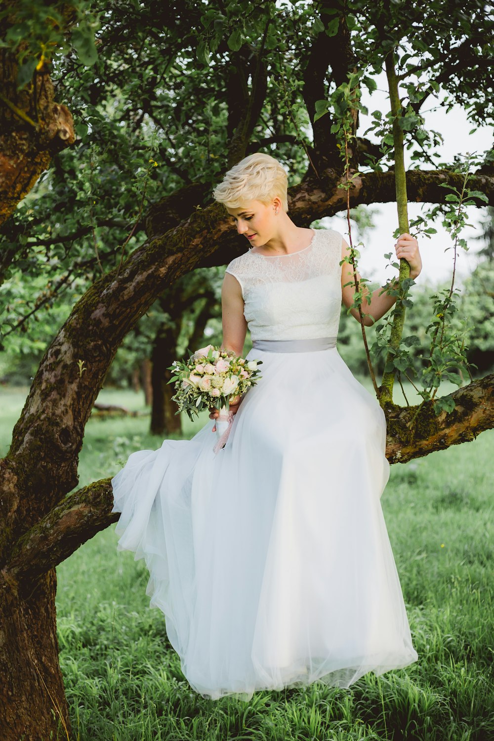 bride sitting on tree branch