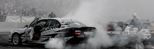 A dynamic shot of the black and red indoor RC track with cars racing on the banked straightaway.