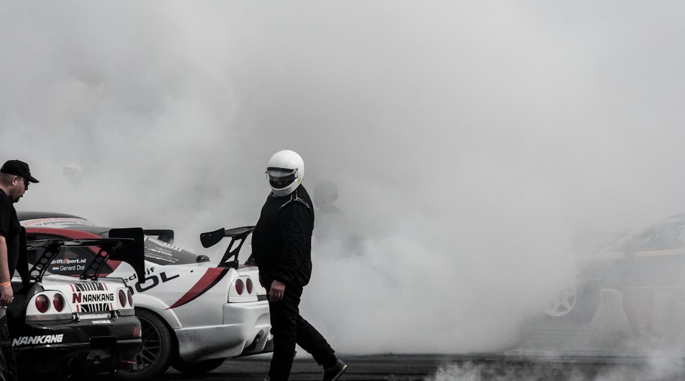 person standing beside racing cars