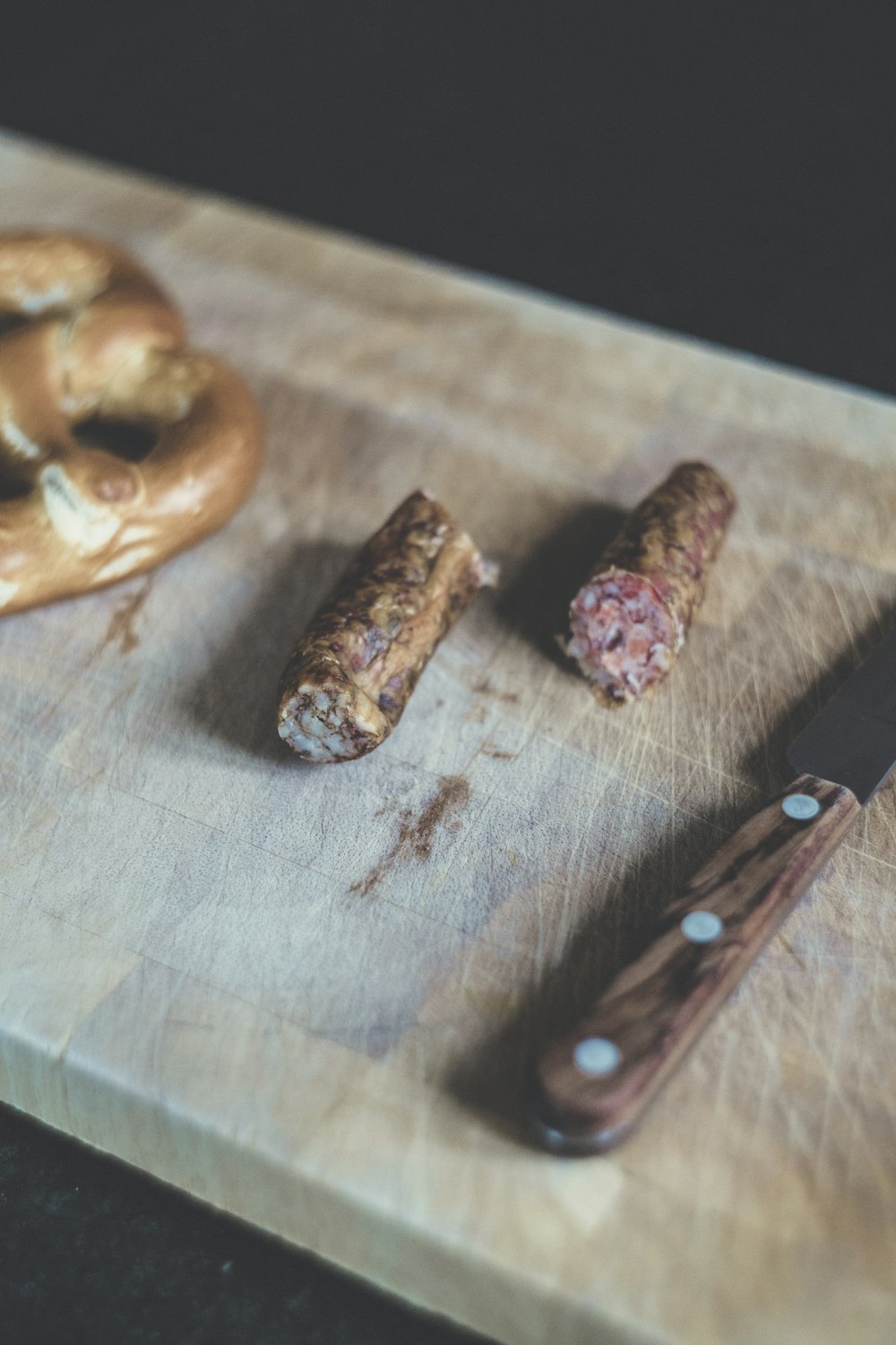 sliced sausage beside brown handle knife