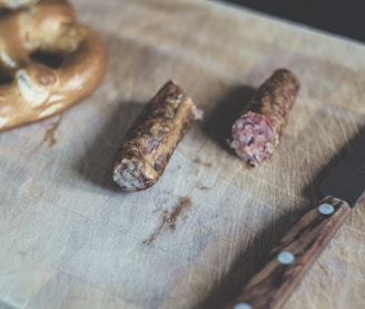 sliced sausage beside brown handle knife