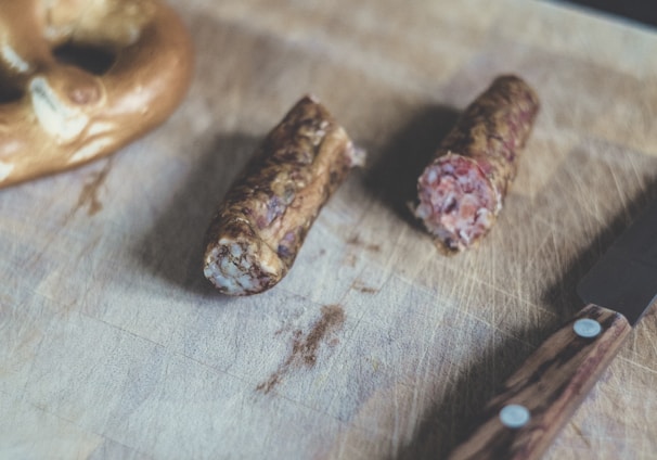 sliced sausage beside brown handle knife