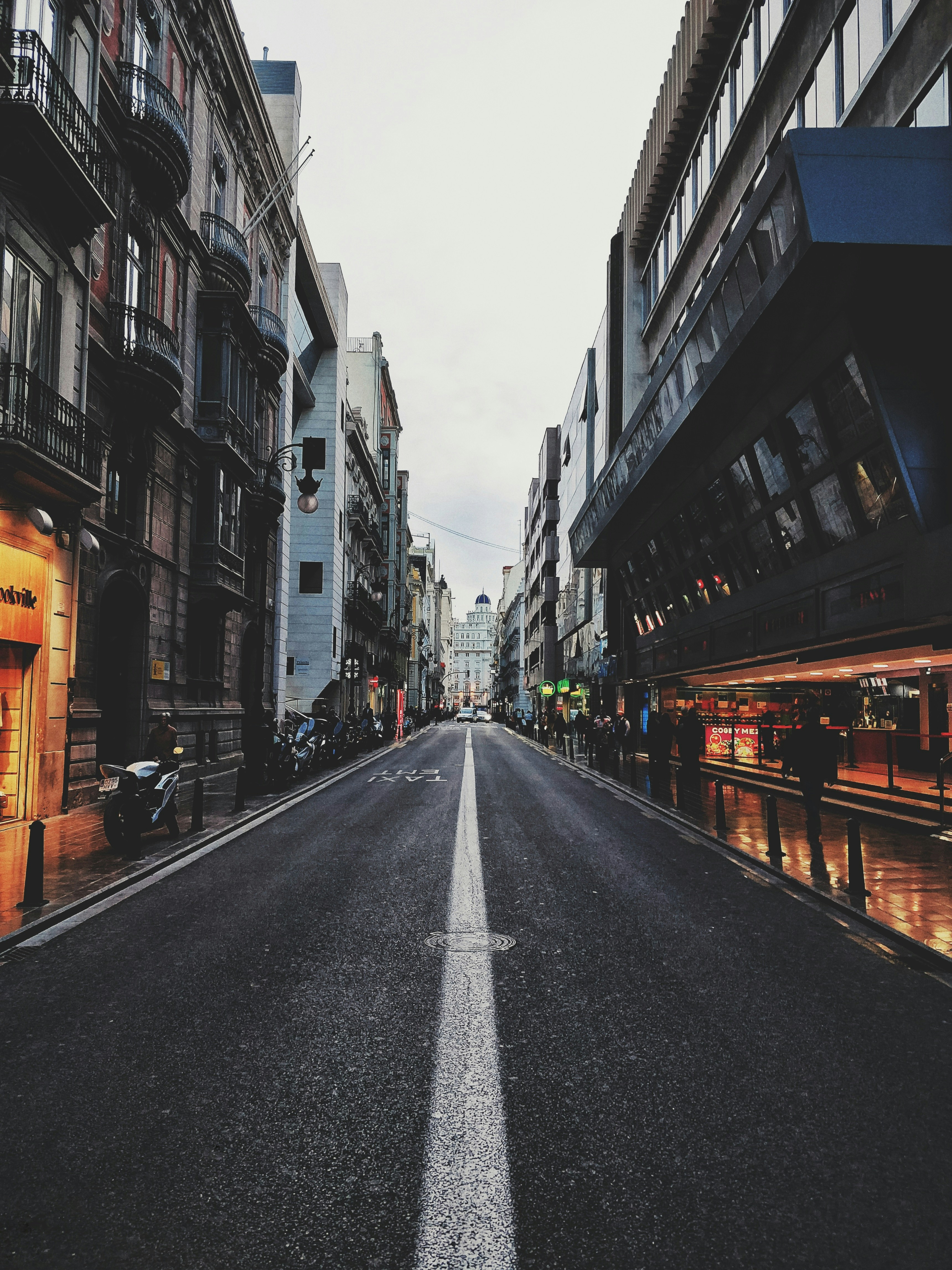 empty road between concrete buildings during daytime