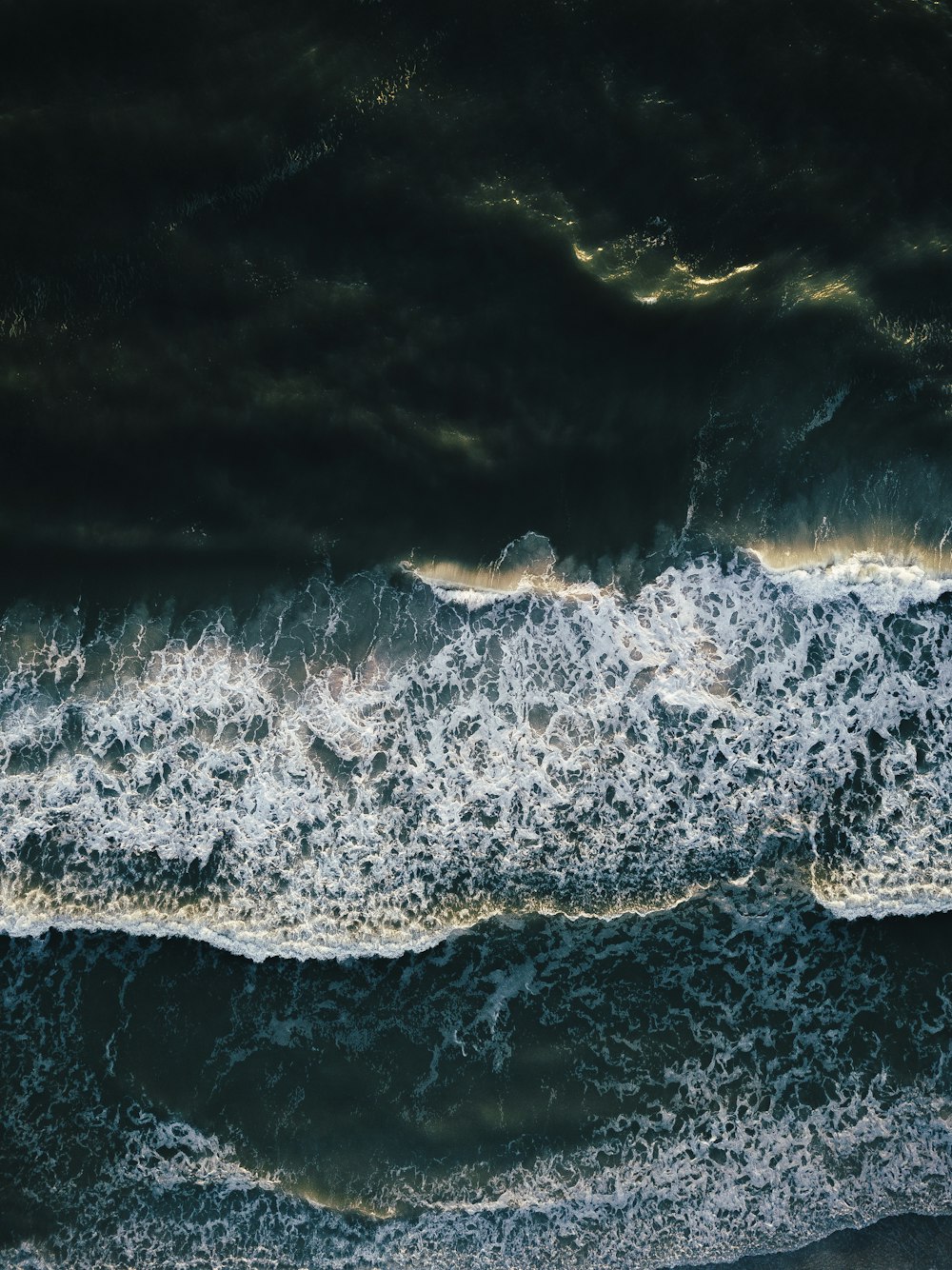 an aerial view of the ocean with waves