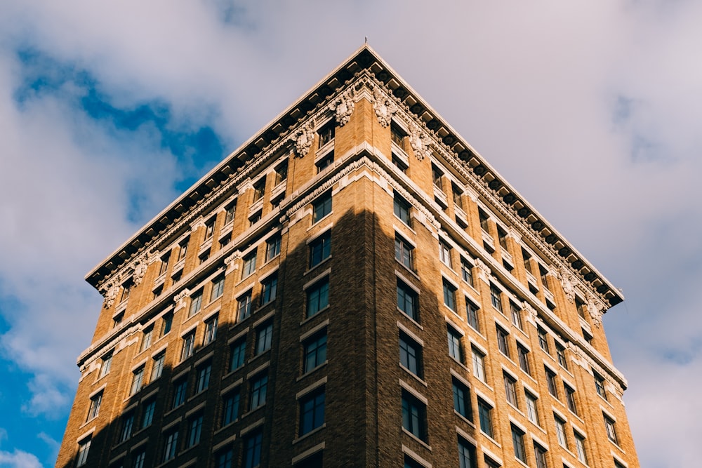 low angle photography of building under cloudy sky at daytime