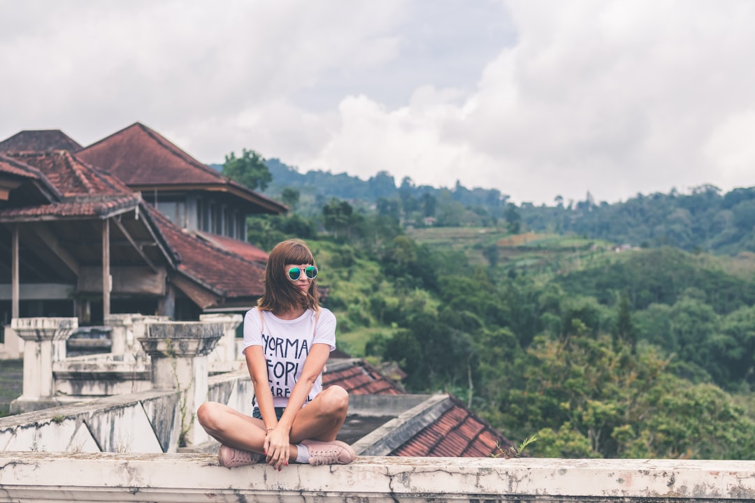 woman sitting on edge of rooftop