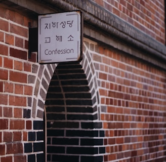 Confession signage beside brown concrete wall