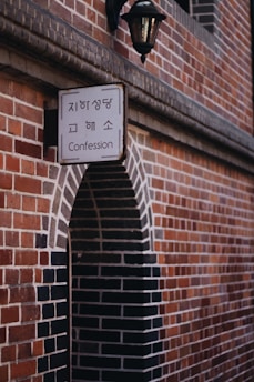 Confession signage beside brown concrete wall