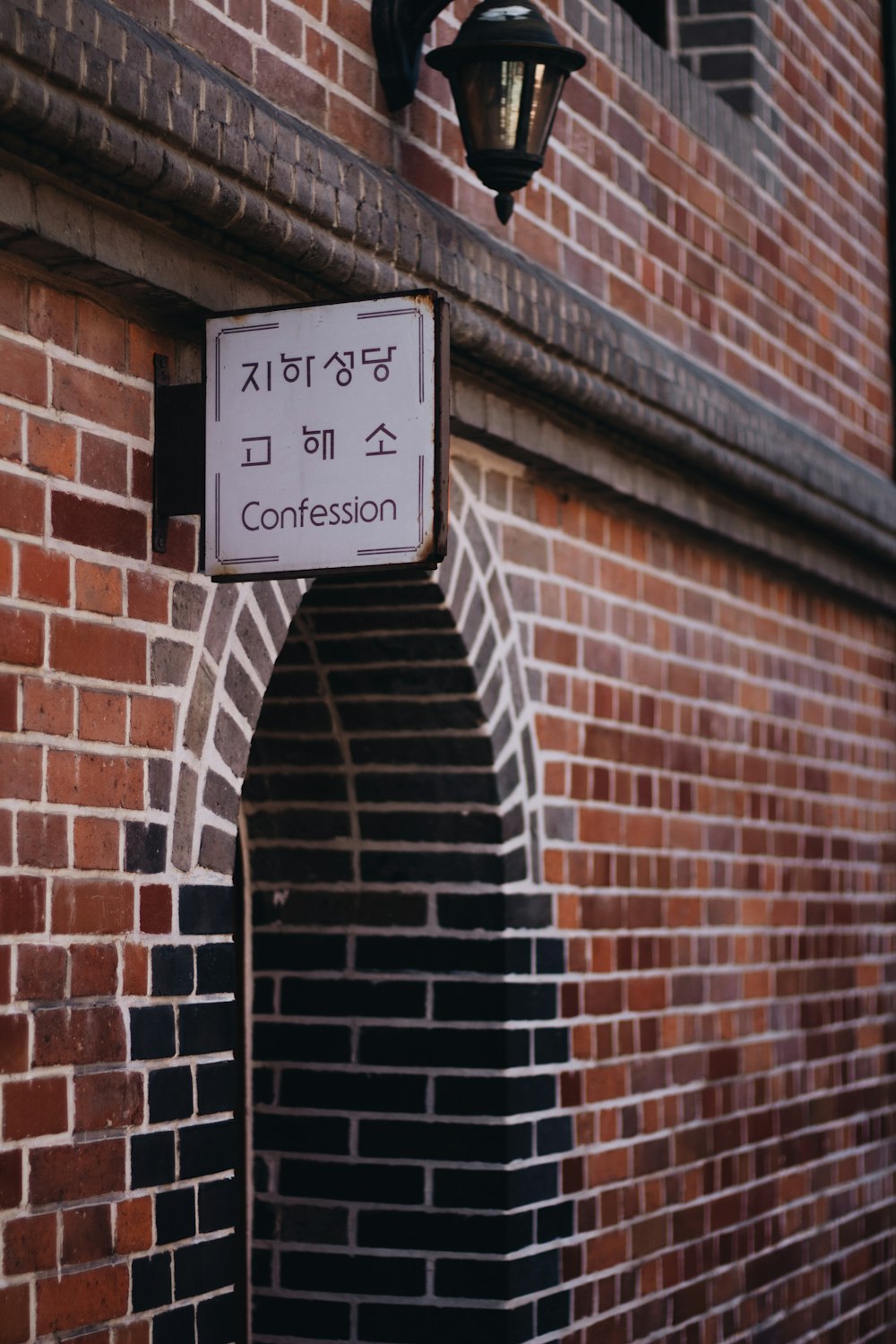 Panneau de confession à côté d’un mur en béton brun