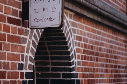 Confession signage beside brown concrete wall