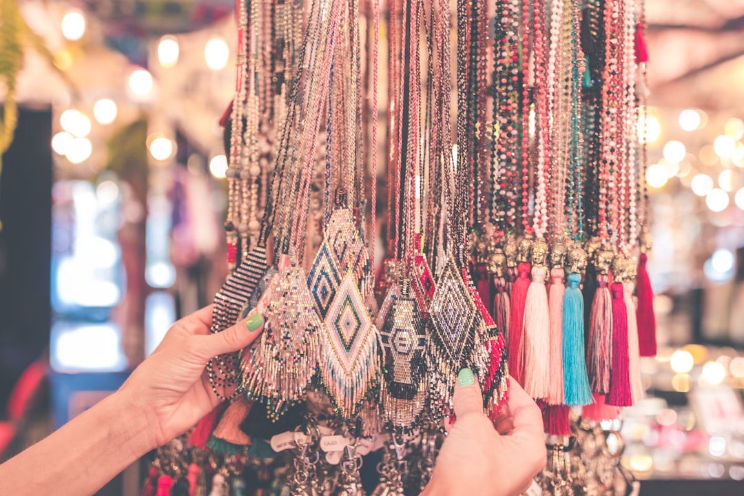 person holding beaded necklaces