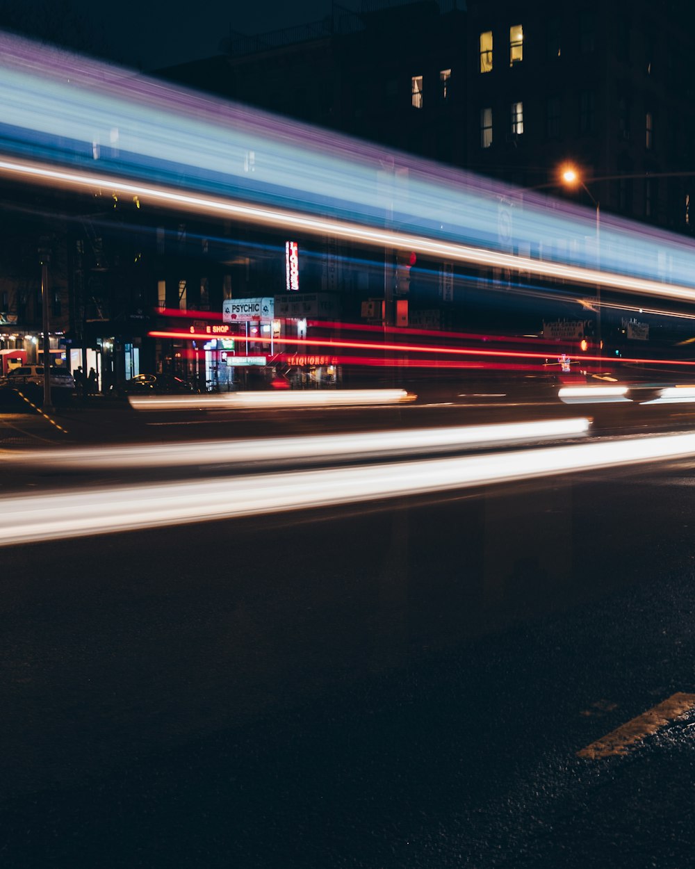 time-lapse photography of vehicle near buildings at night