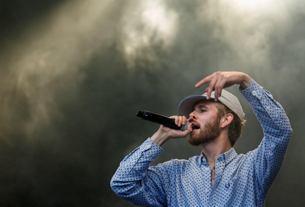 man singing while raising hands